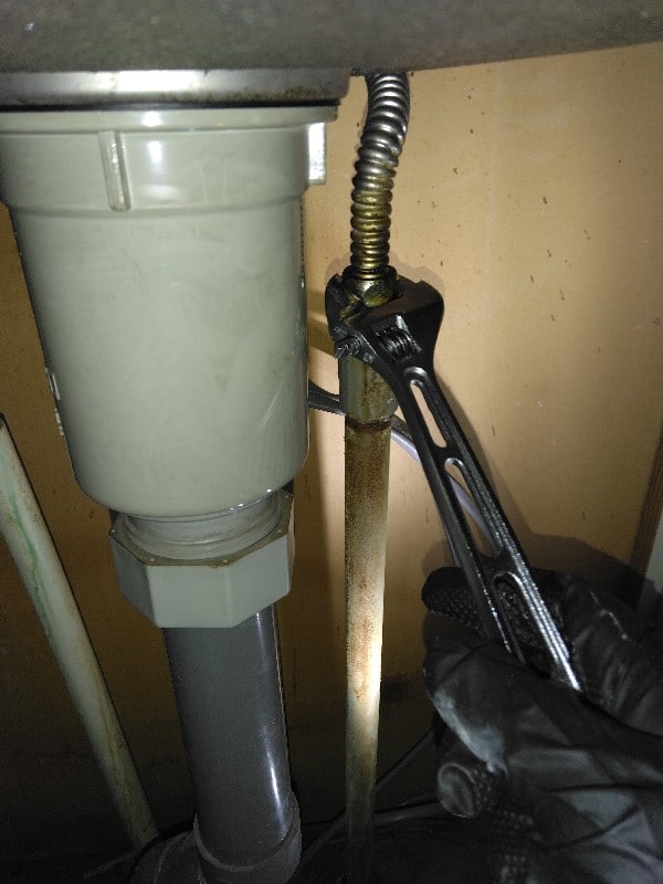 レンチを使い水道管に繋がっている管を取り外します。